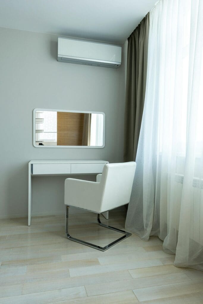 Modern minimalist interior featuring a chair, table, and air conditioning unit.