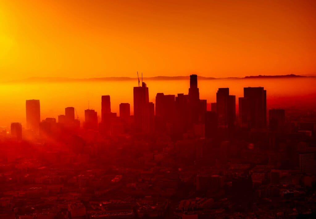 Captivating view of Los Angeles skyline with vibrant sunset hues and silhouette architecture.