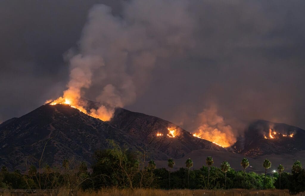 Stunning view of a wildfire blazing across hills at night in Pacific palisades fire CA.