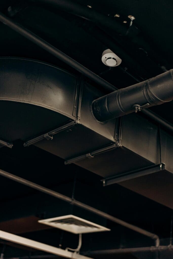 Detailed view of industrial air ducts on a ceiling, showcasing modern urban design.