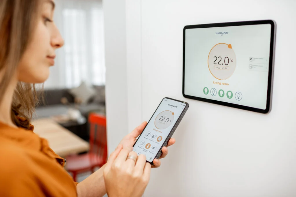 A woman controlling heating with a smart device